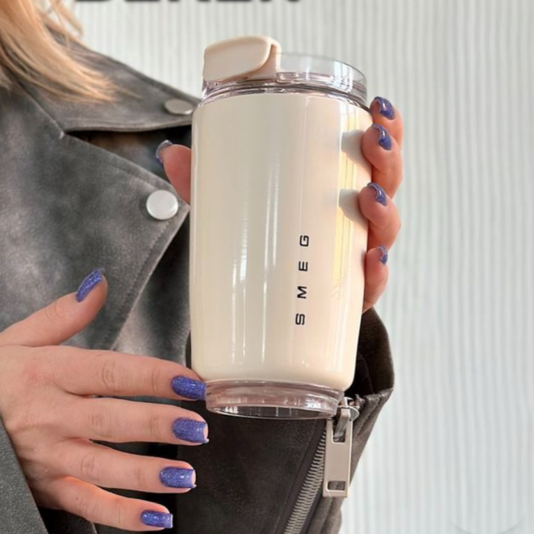 Thermobecher in der Hand, unterwegs genutzt