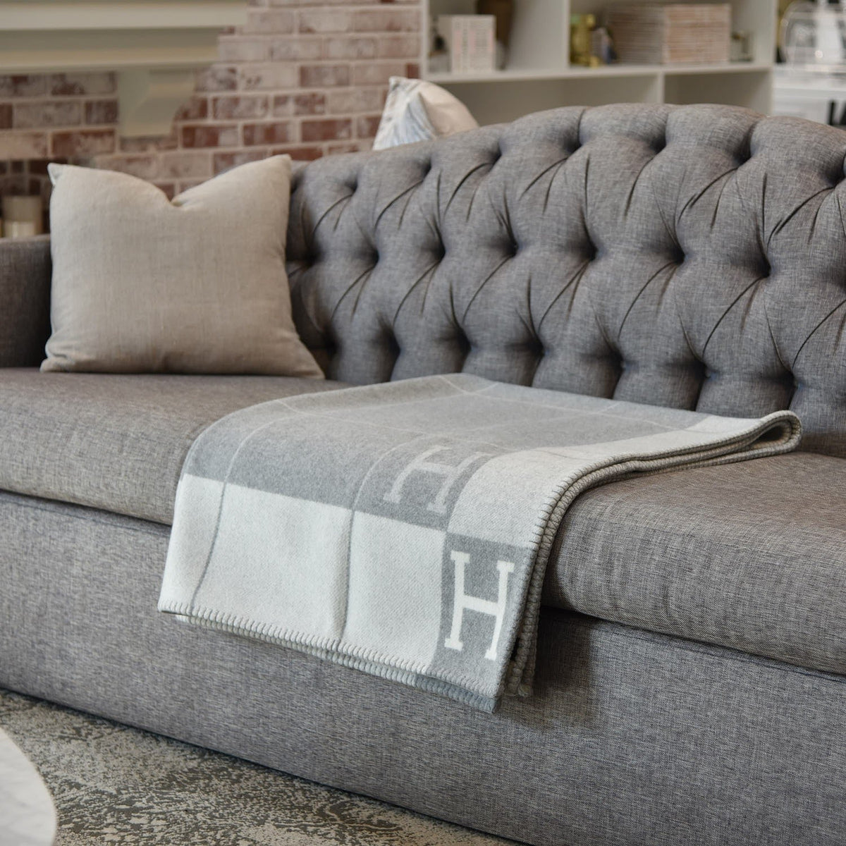 Exklusive Wohndecke aus Wolle und Kaschmir in Beige, auf einem Sofa drapiert